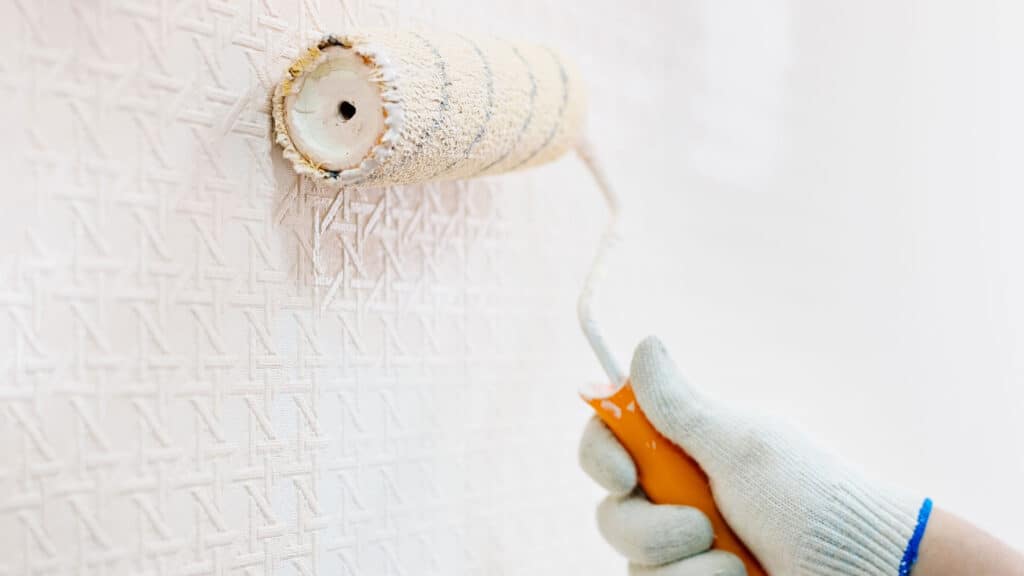 image of painter painting over wallpaper